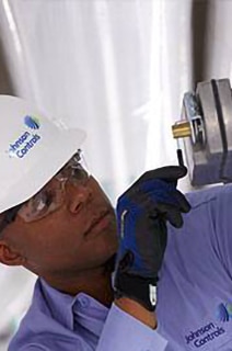 Mechanic wearing safety helmet inspecting a device