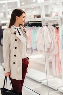 Woman walking past a clothing store in a mall