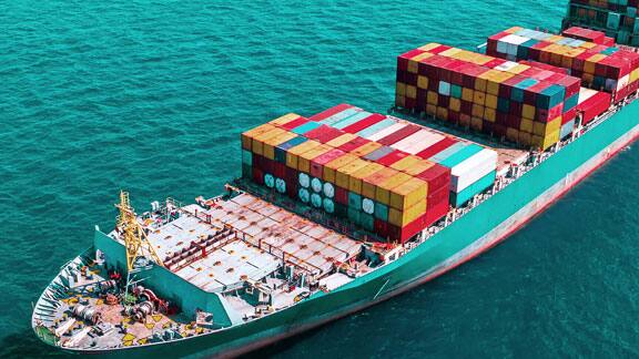 A massive cargo ship carrying containers sailing in the ocean