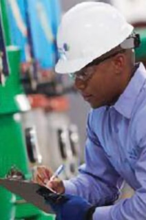 Mechanic wearing safety helmet inspecting a device