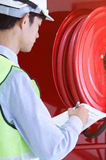 Security personnel inspecting a fire extinguishing waterhose