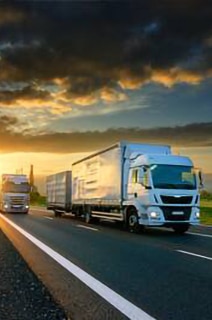 Two trucks on a highway during sunset