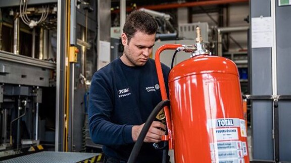 A firefighter inspecting a fire extinguisher