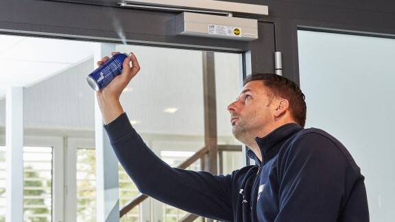 A person spraying fire extinguishing spray in an indoor space