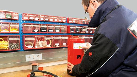 Firefighter attaching a label on a fire extinguisher