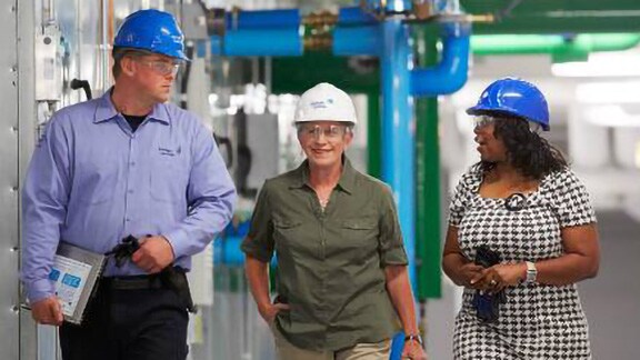 Group of engineers wearing safety helmets having a conversation