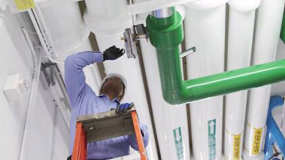A technician inspecting a gas pipe